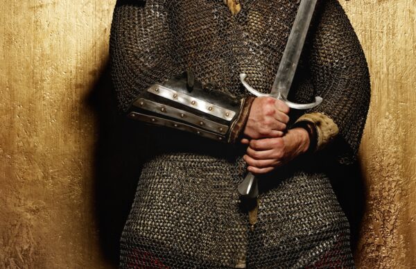 Knight holding sword on golden background.