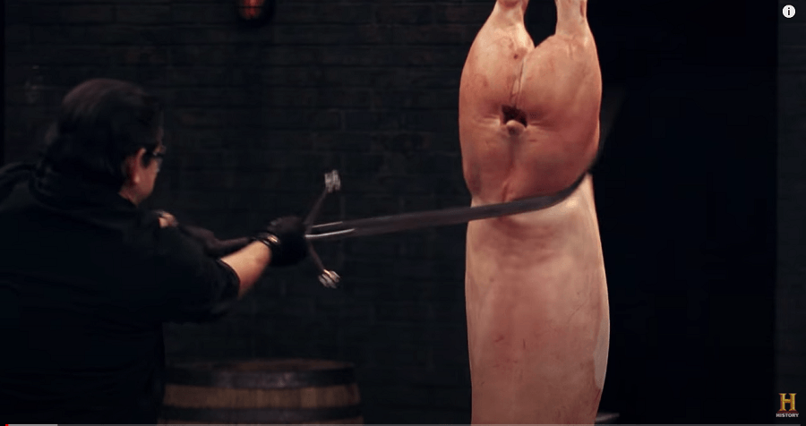 The result is that the blade rotates in his right hand as he loses control of the fulcrum, as his index finger is overpowered by the force resisted against the blade by the pig carcass. This causes he flat of the edge to hit the pig carcass.  